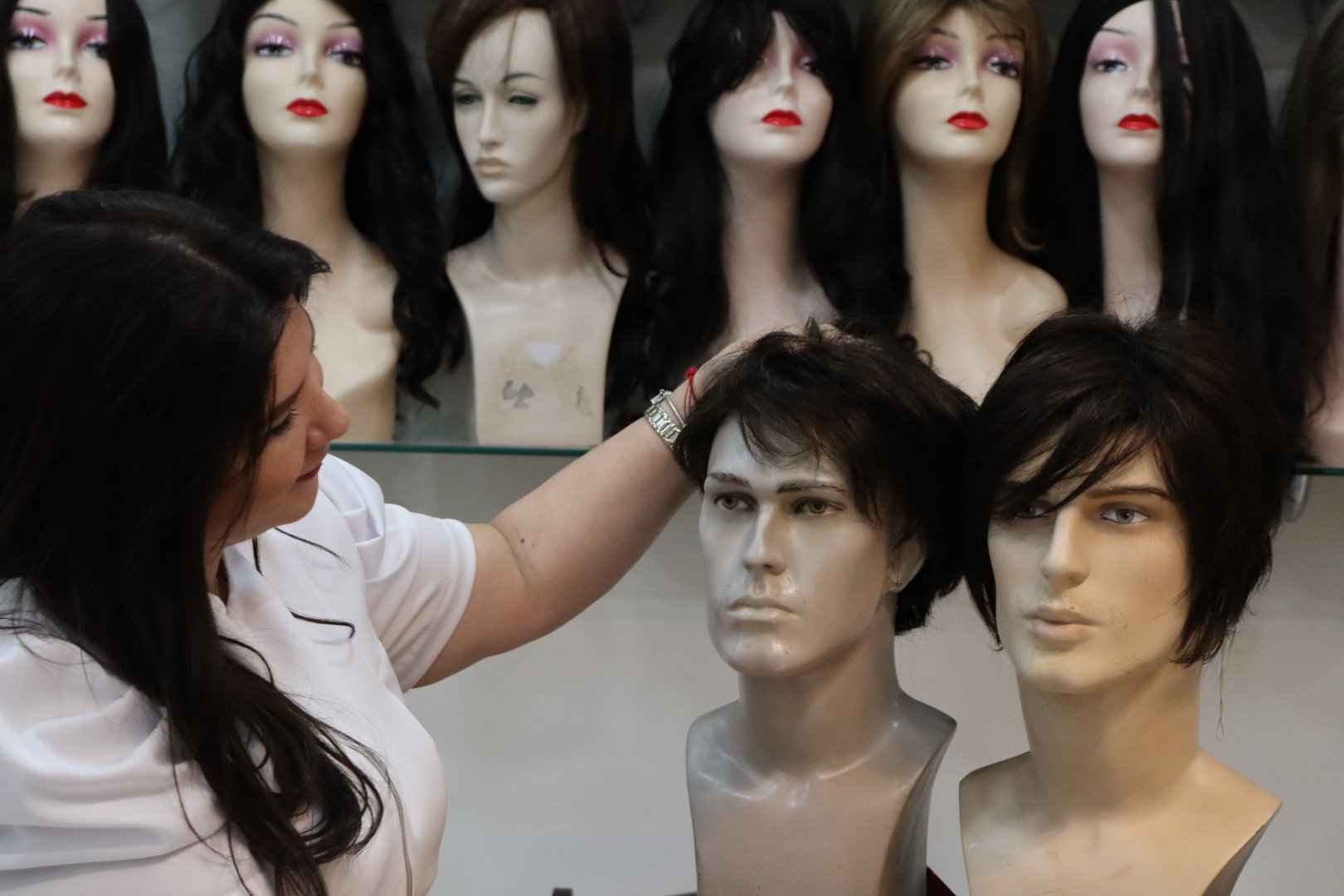 Cristina Orosa ajustando uma prótese capilar em manequim — expertise técnica de 30 anos